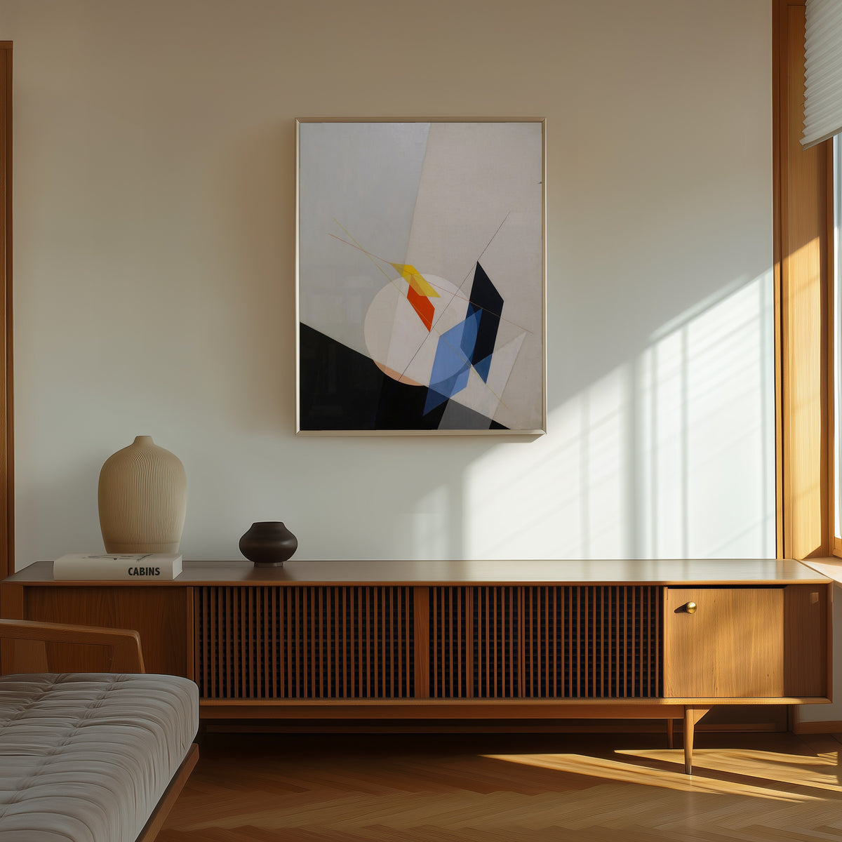 Framed art print of A 18 by László Moholy-Nagy, in a thin light frame on a sunlit wall above a wooden sideboard