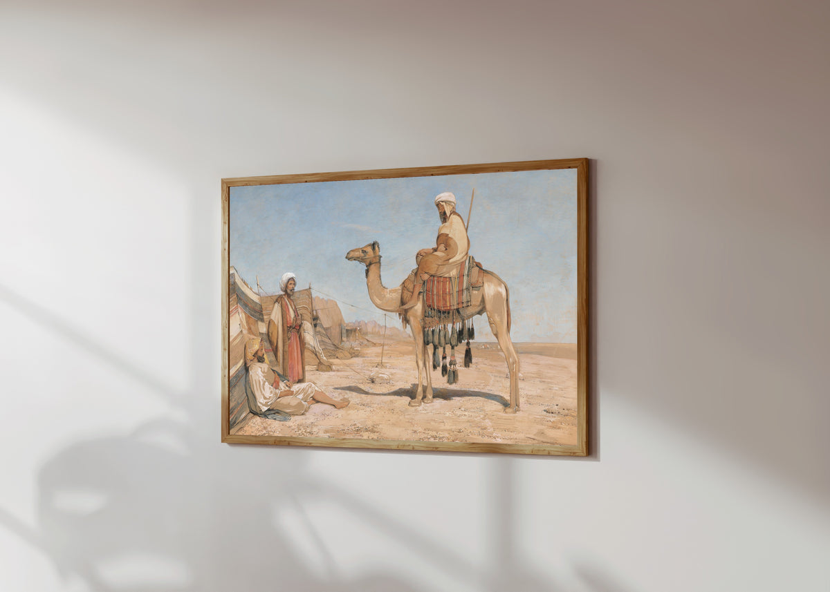 Framed art print of A Bedouin Encampment; or, Bedouin Arabs by John Frederick Lewis, in a light wood frame on a sunlit white wall, seen at a slight angle