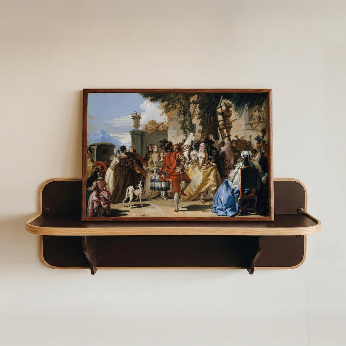 Framed art print of A Dance in the Country by Giovanni Domenico Tiepolo, in a dark wood frame resting on a wall shelf