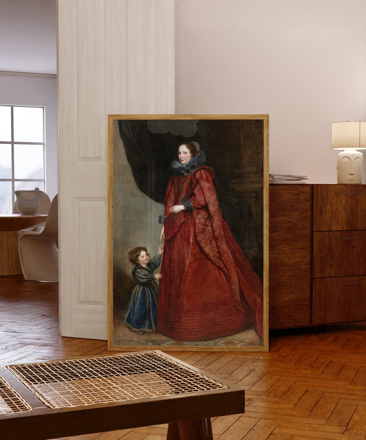 Framed art print of A Genoese Lady with Her Child by Anthony van Dyck, in a light wood frame leaning in a warm room with a parquet floor