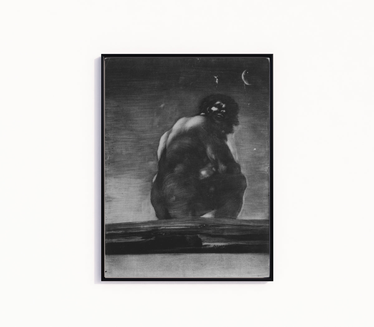 Framed art print of A Giant Seated in a Landscape (The Colossus) by Francisco de Goya, in a slim black frame on a plain white wall