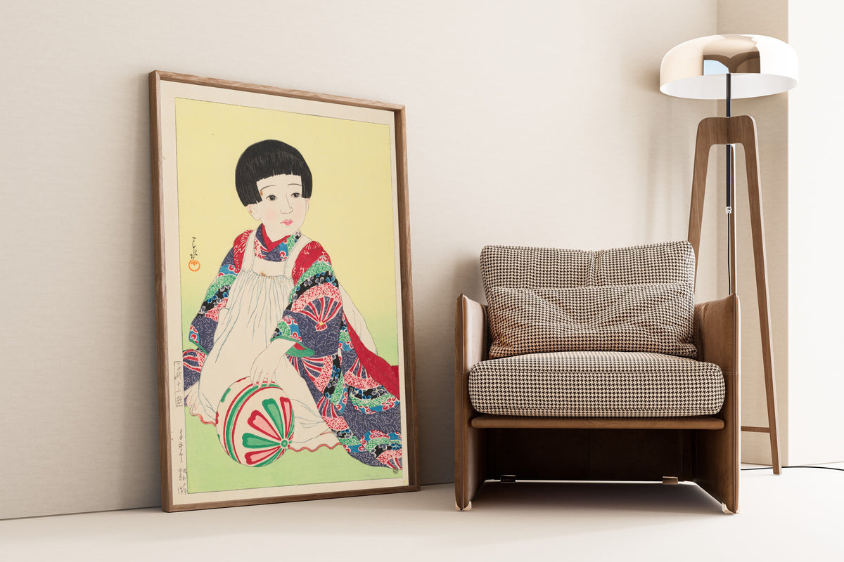 Framed art print of A Hand Ball, Portrait of Takagi Junko by Kawase Hasui, leaning against a wall beside an armchair and a floor lamp