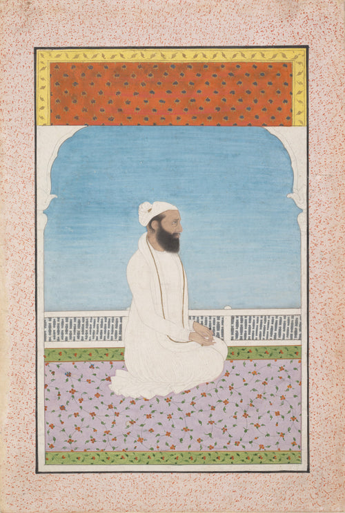 A Holy Man Seated on a Terrace by Kangra school — A bearded holy man in white sits on a floral carpet under a blue arch