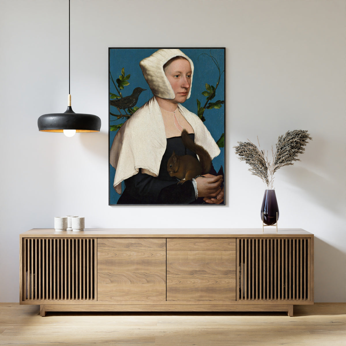 Framed art print of A Lady with a Squirrel and a Starling by Hans Holbein the Younger, above a slatted wood sideboard