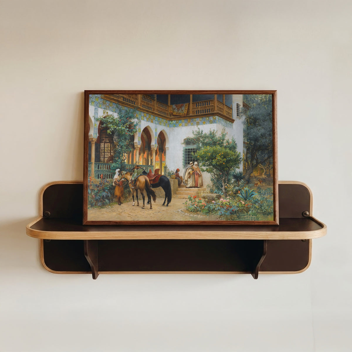 Framed art print of A North African Courtyard by Frederick Arthur Bridgman, in a dark wood frame resting on a wall shelf