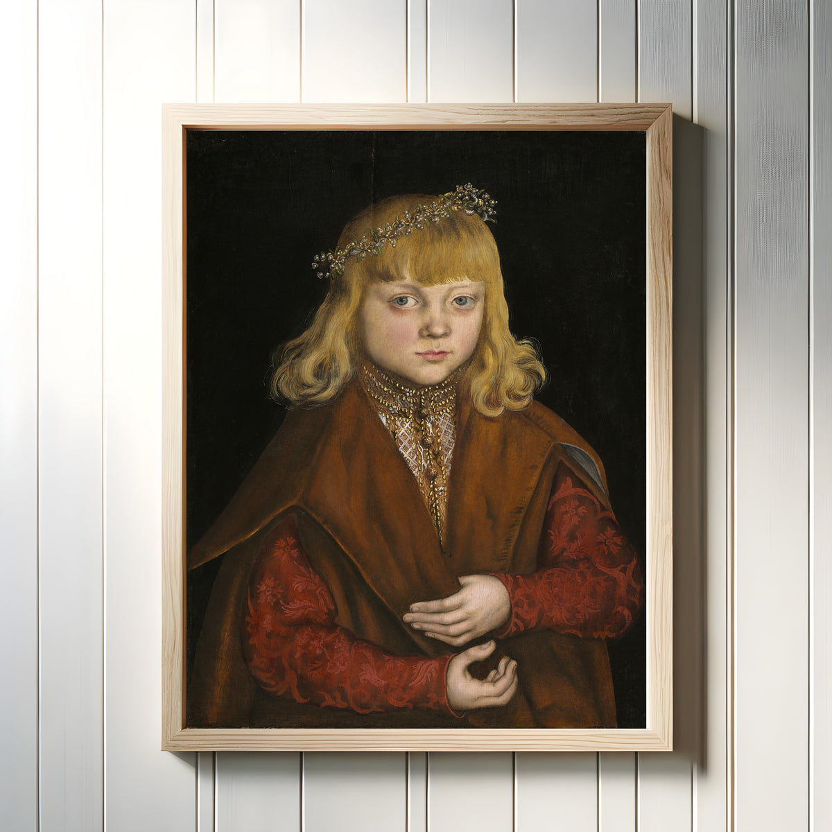 Framed art print of A Prince of Saxony by Lucas Cranach the Elder, in a light wood frame on a white panelled wall