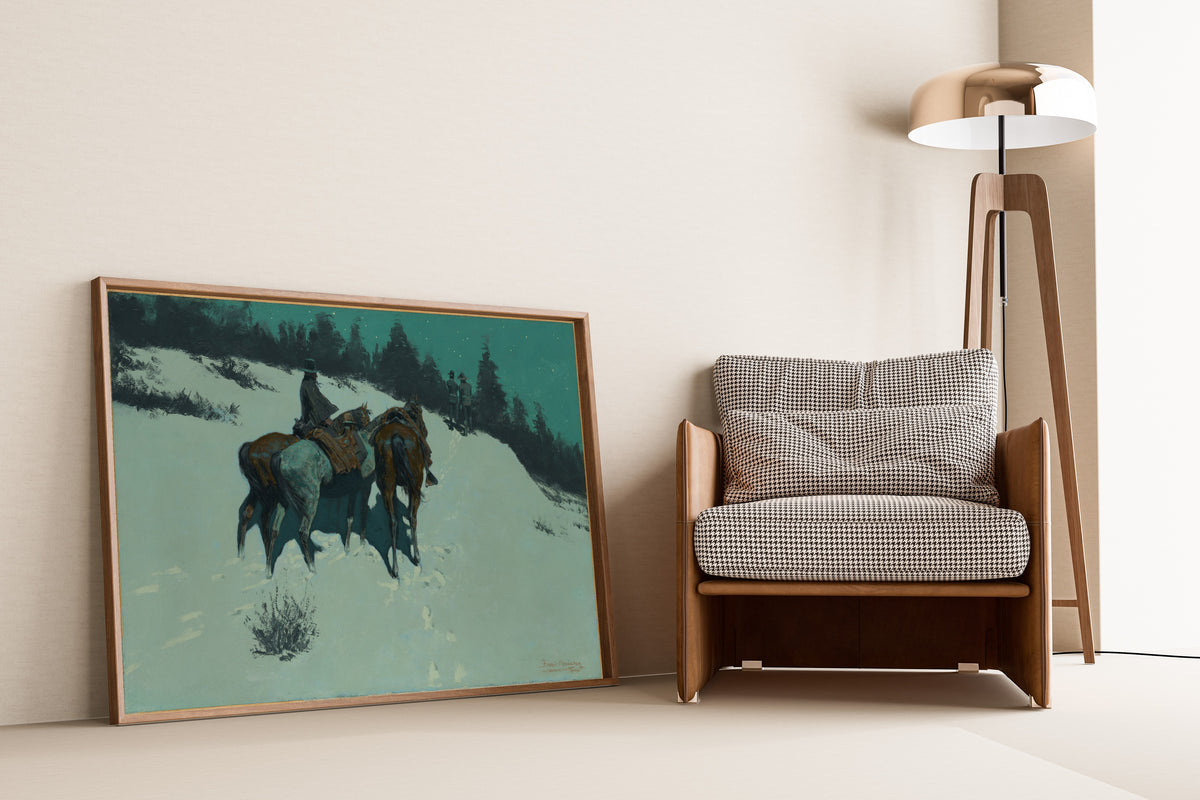 A Reconnaissance by Frederic Remington — framed and leaning against a wall beside an armchair and a floor lamp