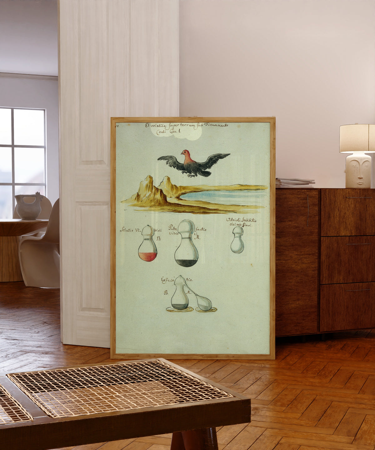 Framed art print of A Red-Headed Bird over a Lake, above Three… by Thesaurus Thesaurorum, in a light wood frame leaning in a warm room with a parquet floor