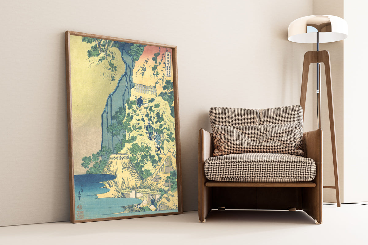 Framed art print of A Tour of the Waterfalls of the Provinces: Kiyotaki… by Katsushika Hokusai, leaning against a wall beside an armchair and a floor lamp