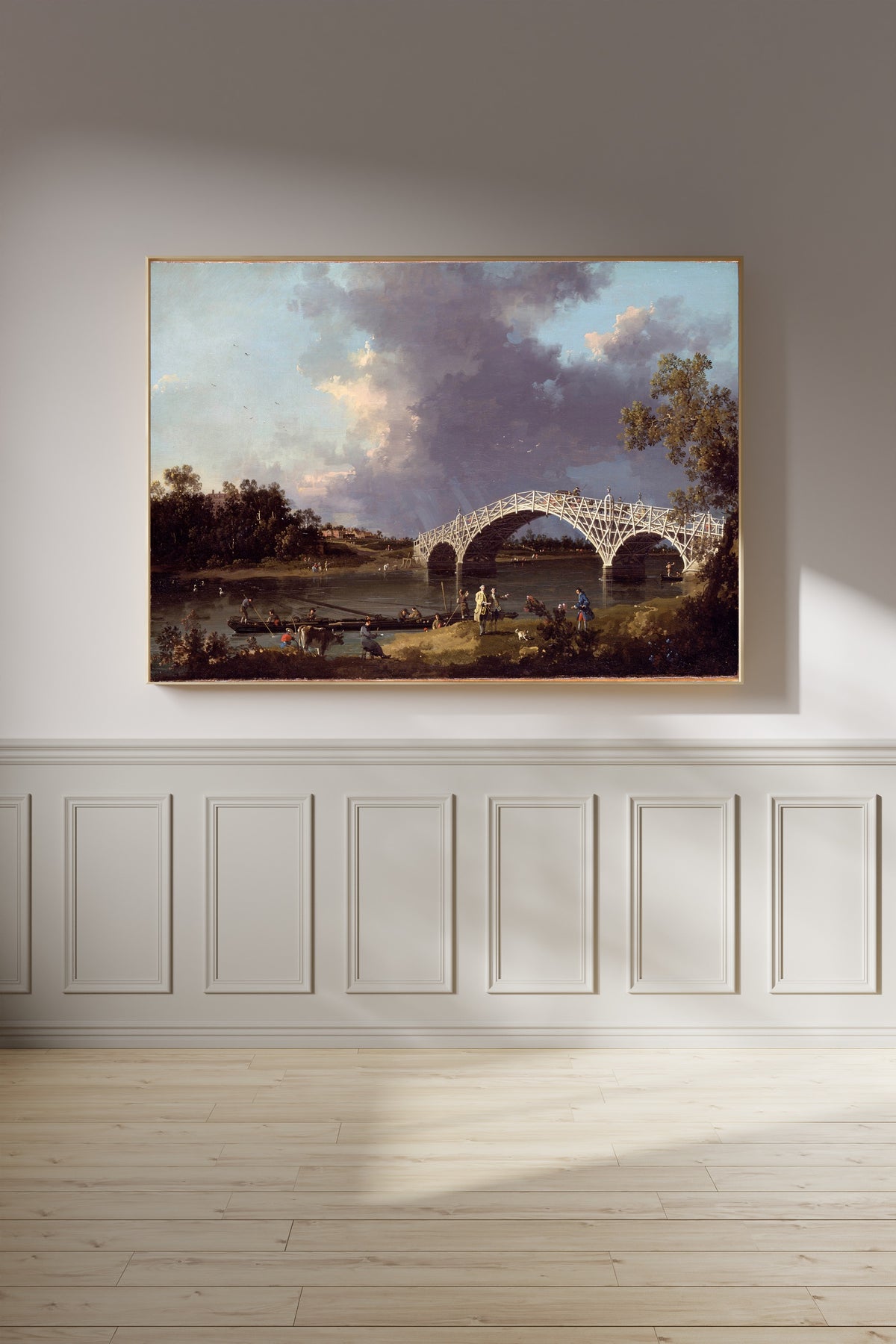 Framed art print of A View of Walton Bridge by Canaletto, on a panelled wall in afternoon light