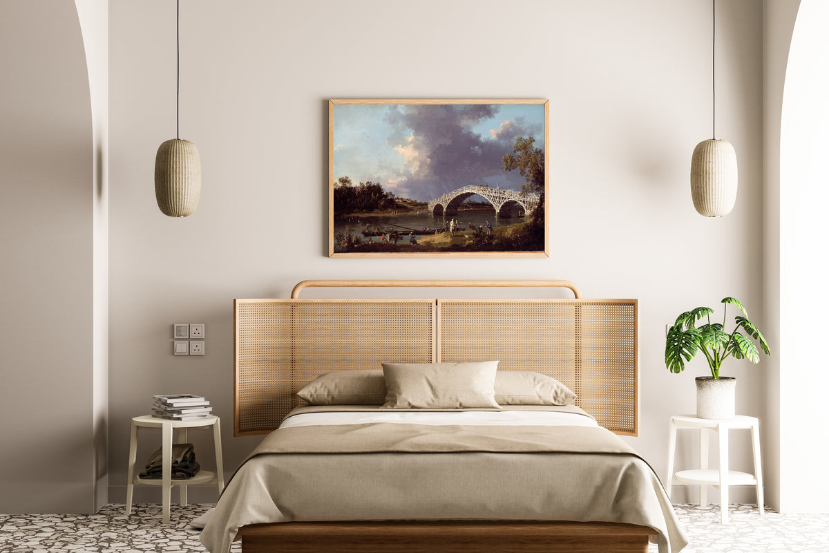 Framed art print of A View of Walton Bridge by Canaletto, above a cane-headboard bed