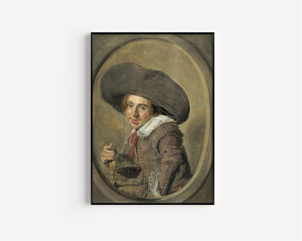 Framed art print of A Young Man in a Large Hat by Frans Hals, in a slim black frame on a plain white wall
