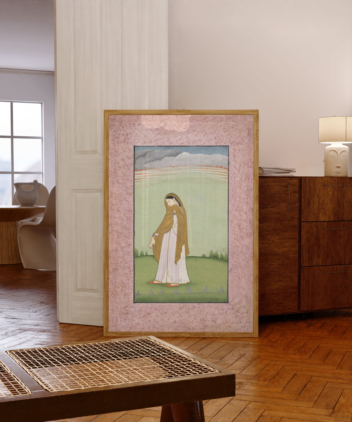 Framed art print of Abhisarika Nayika, a Heroine Longing for Her Lover by Kangra school, in a light wood frame leaning in a warm room with a parquet floor