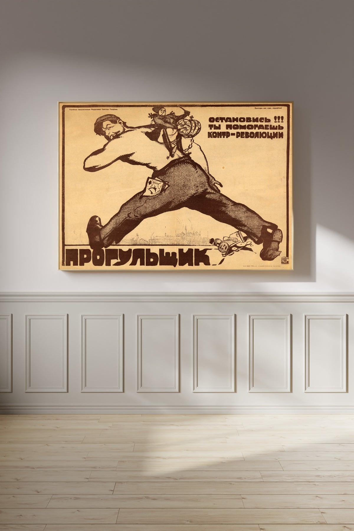 Framed art print of Absentee, Stop! You Are Helping the Counter-revolution! by Vasily Kostyanitsyn, on a panelled wall in afternoon light