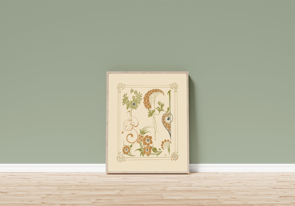 Framed art print of Abstract design based on flowers and arabesques by Alphonse Mucha, in a light wood frame leaning on a sage green wall above a wooden floor
