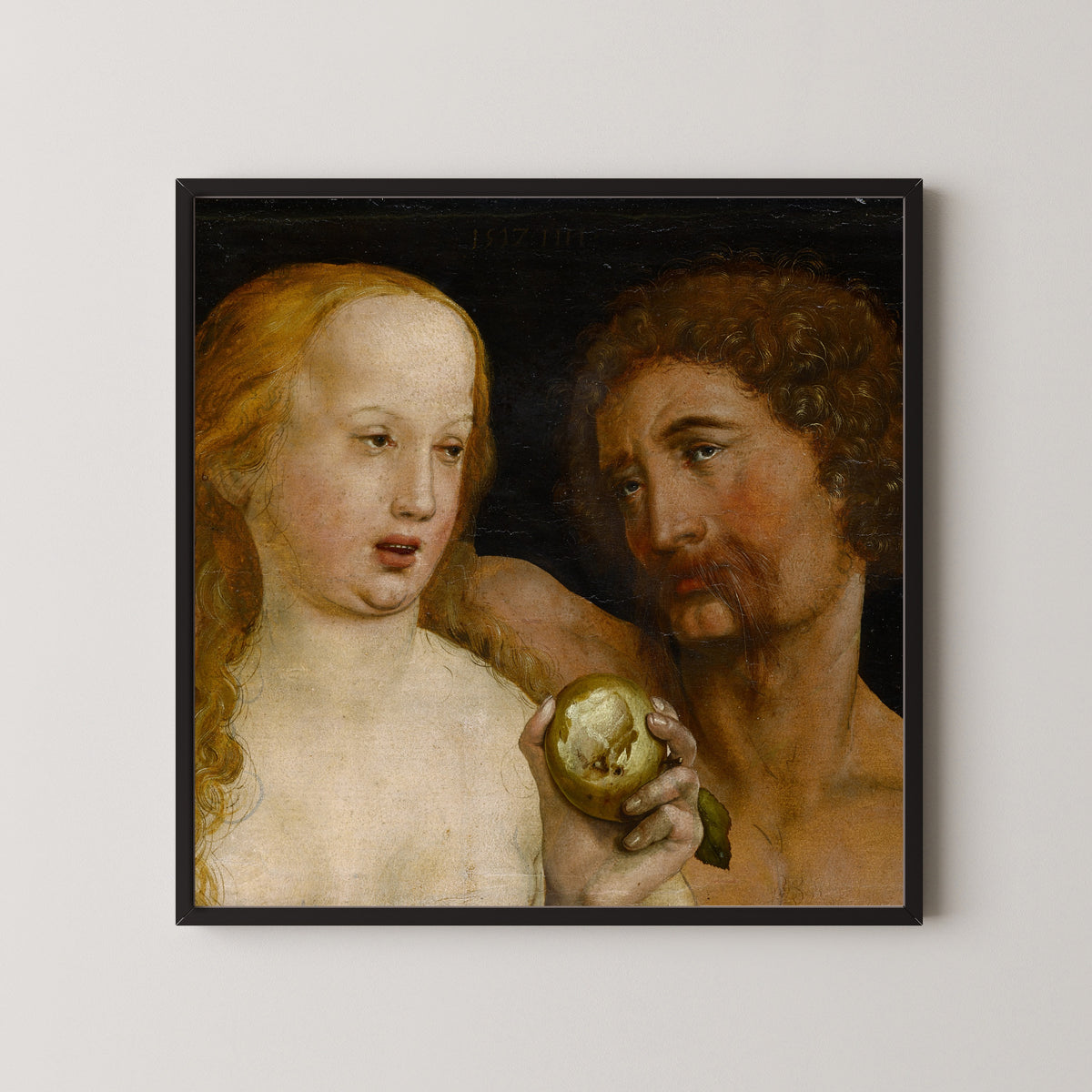 Framed art print of Adam and Eve by Hans Holbein the Younger, in a black frame on a pale wall