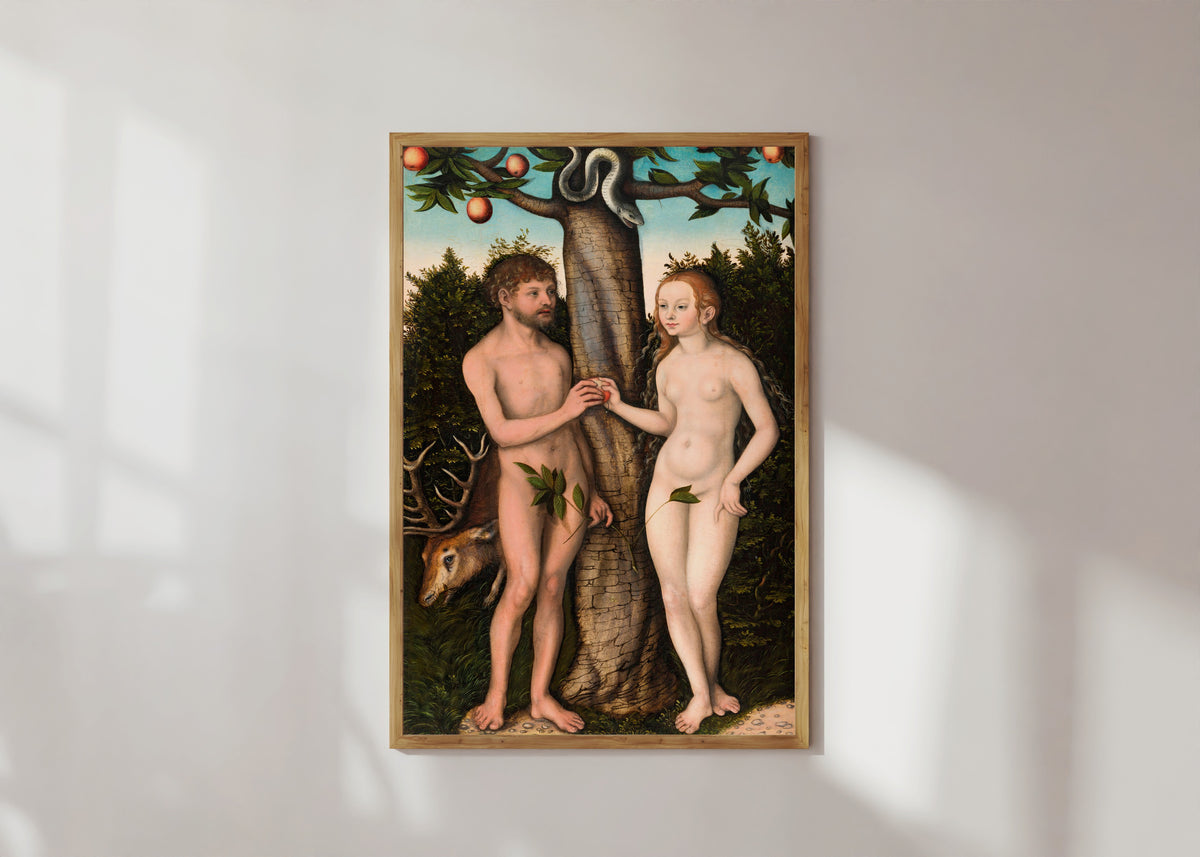 Framed art print of Adam and Eve by Lucas Cranach the Elder, in a light wood frame on a sunlit white wall