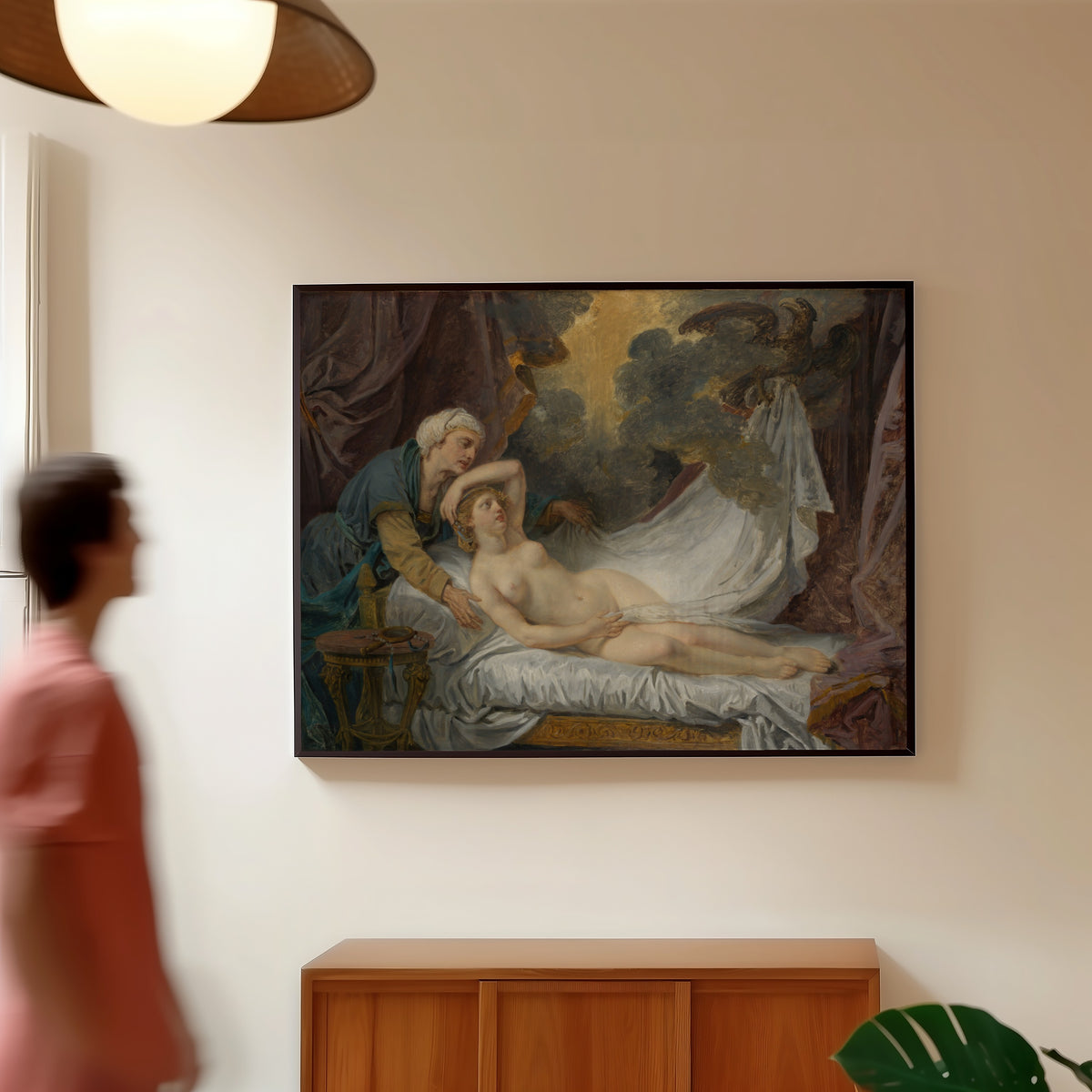 Framed art print of Aegina Visited by Jupiter by Jean-Baptiste Greuze, in a slim black frame on a warm wall in a sunlit room