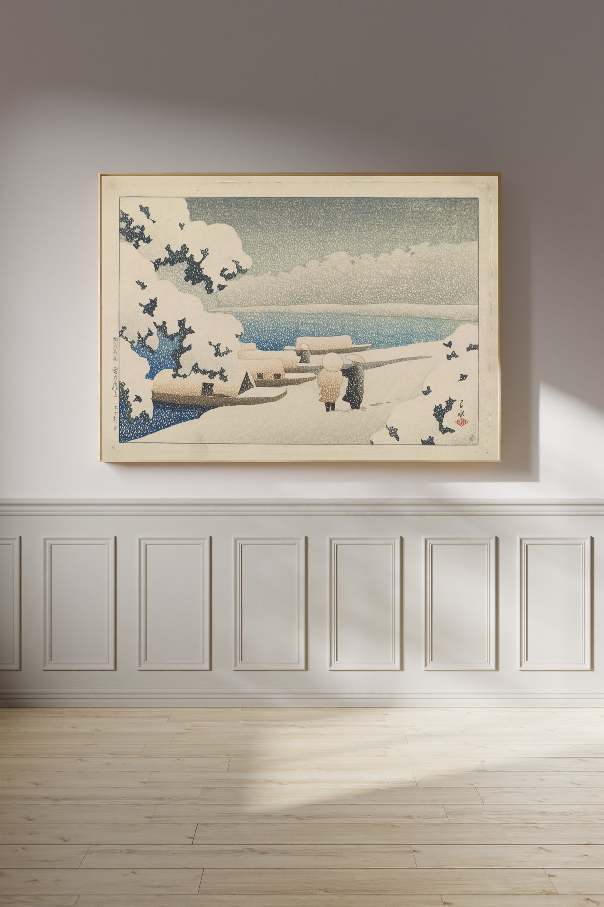 Framed art print of Amanohashidate in Snow by Kawase Hasui, on a panelled wall in afternoon light