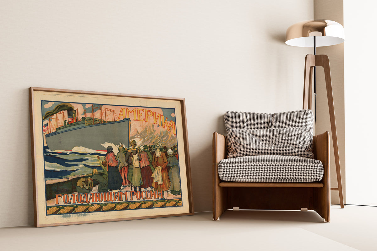 Framed art print of America to the Starving of Russia, leaning against a wall beside an armchair and a floor lamp