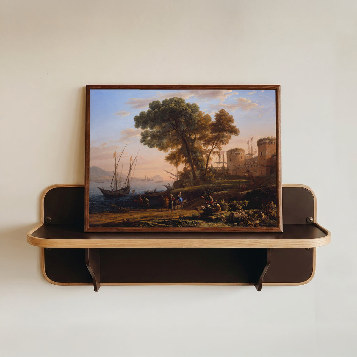 Framed art print of An Artist Studying from Nature by Claude Lorrain, in a dark wood frame resting on a wall shelf