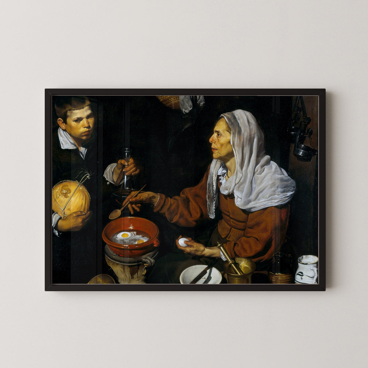 Framed art print of An Old Woman Cooking Eggs by Diego Velázquez, in a black frame on a pale wall
