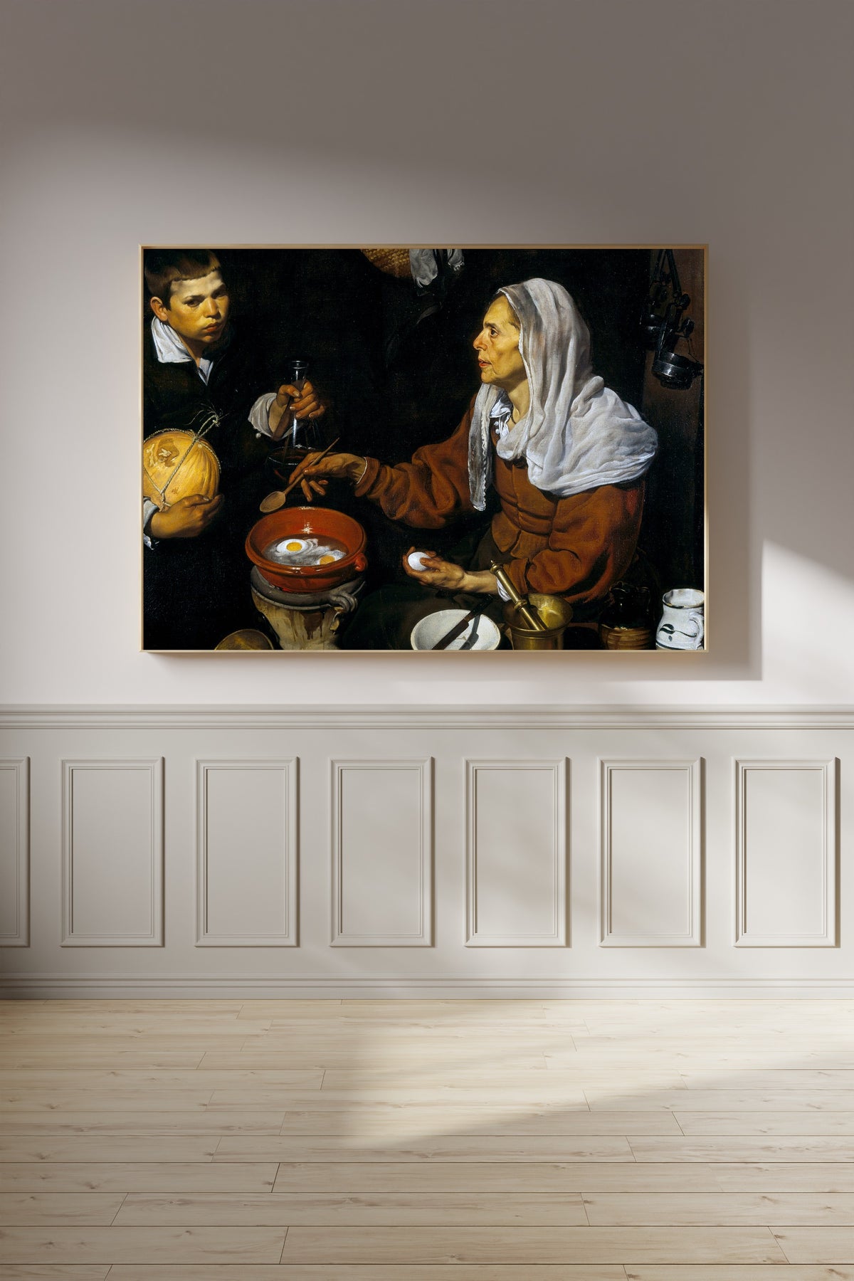 Framed art print of An Old Woman Cooking Eggs by Diego Velázquez, on a panelled wall in afternoon light