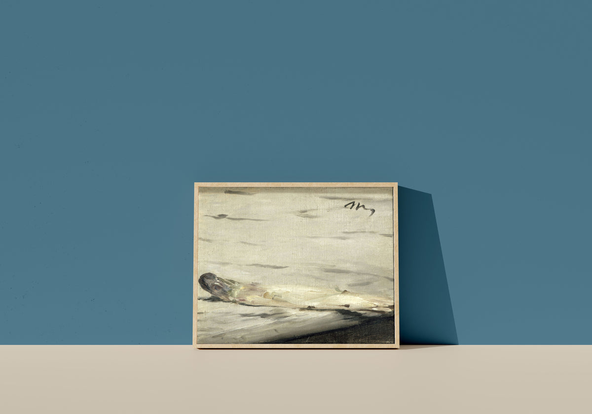 Framed art print of Asparagus by Édouard Manet, in a light wood frame leaning on a blue wall