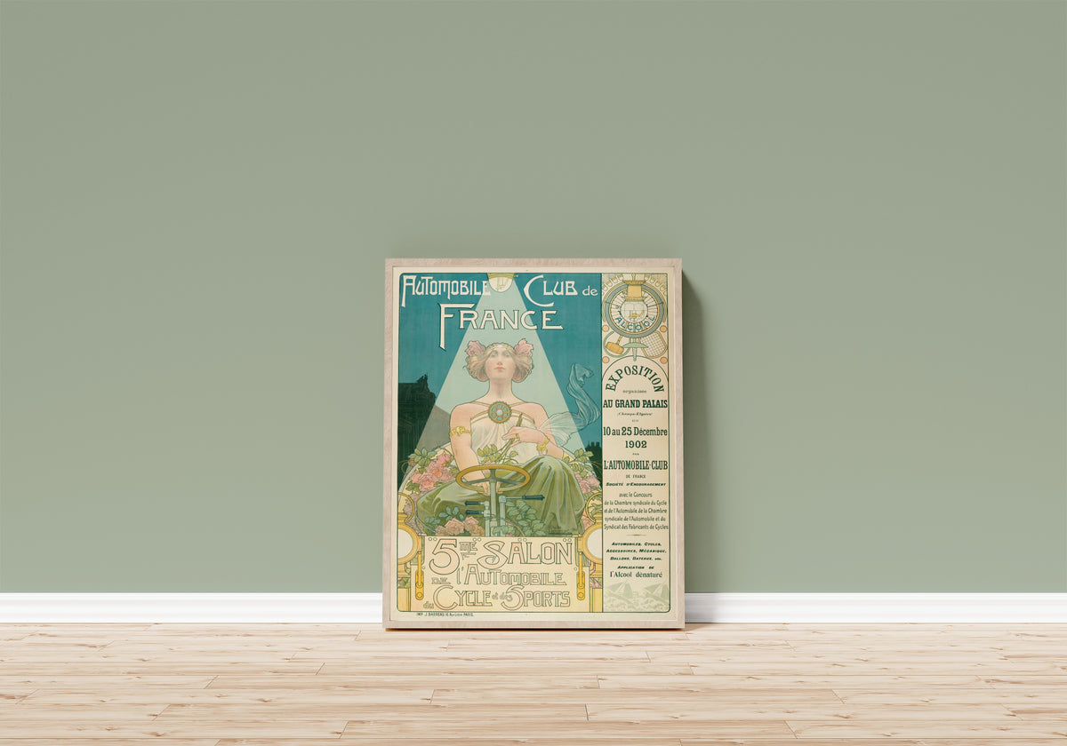 Framed art print of Automobile Club de France, 5me Salon de… by Henri Privat-Livemont, in a light wood frame leaning on a sage green wall above a wooden floor