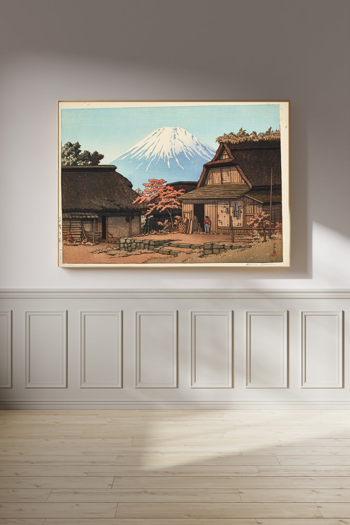 Framed art print of Autumn at Hirano by Kawase Hasui, on a panelled wall in afternoon light