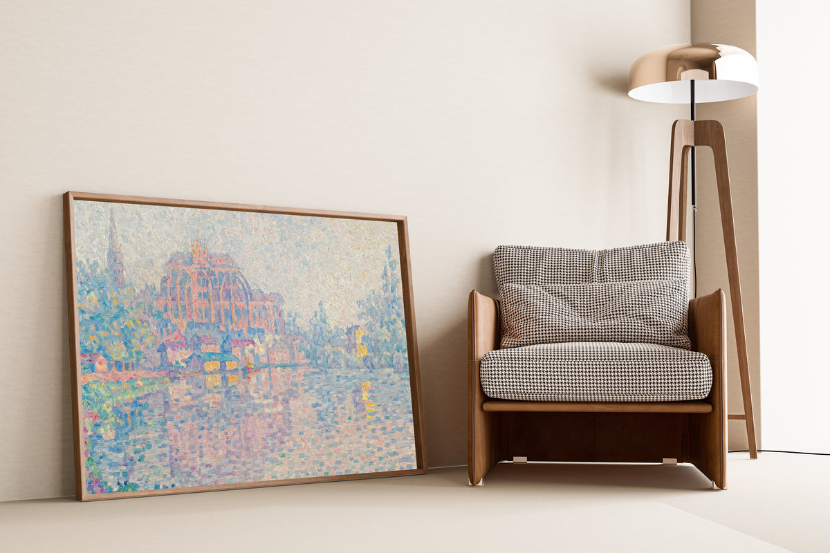 Framed art print of Auxerre, The River by Paul Signac, leaning against a wall beside an armchair and a floor lamp