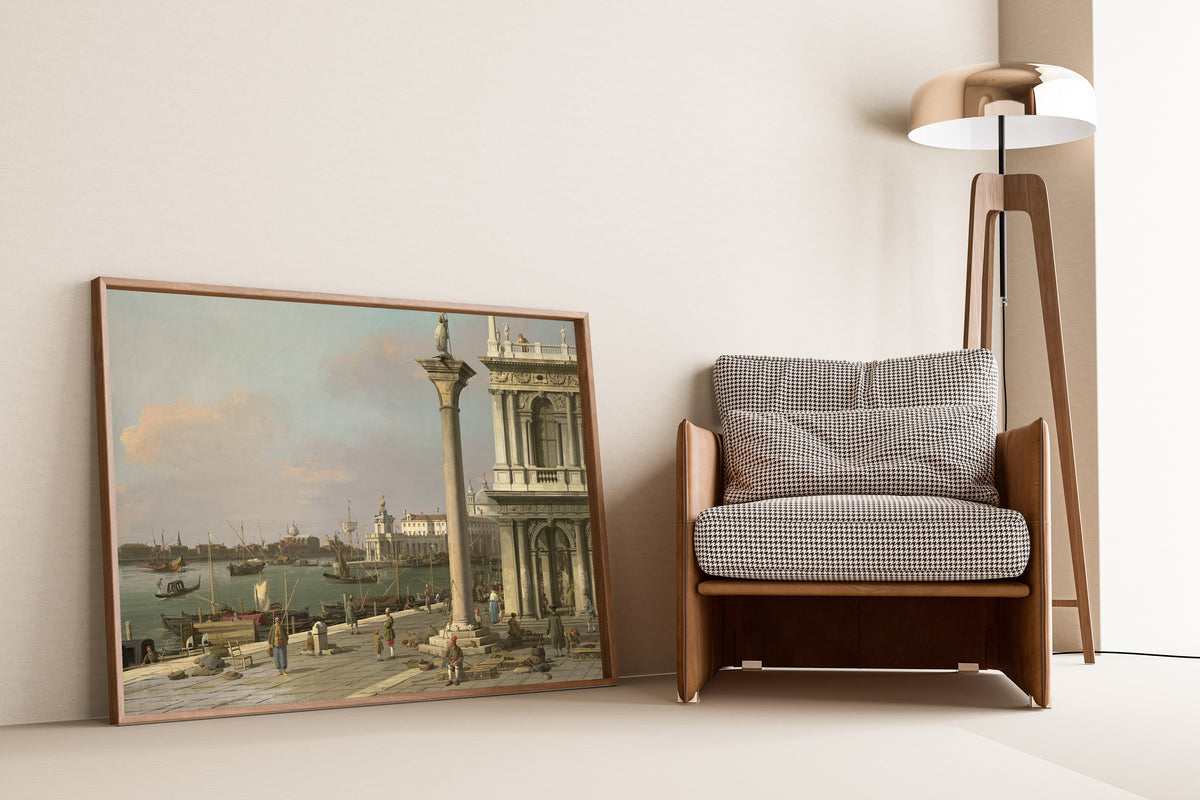 Framed art print of Bacino di S. Marco – From the Piazzetta by Canaletto, leaning against a wall beside an armchair and a floor lamp