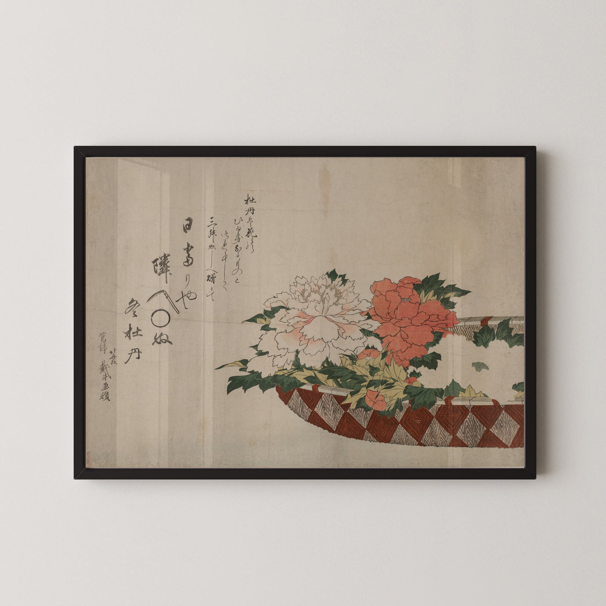 Framed art print of Basket of Peonies by Katsushika Hokusai, in a black frame on a pale wall