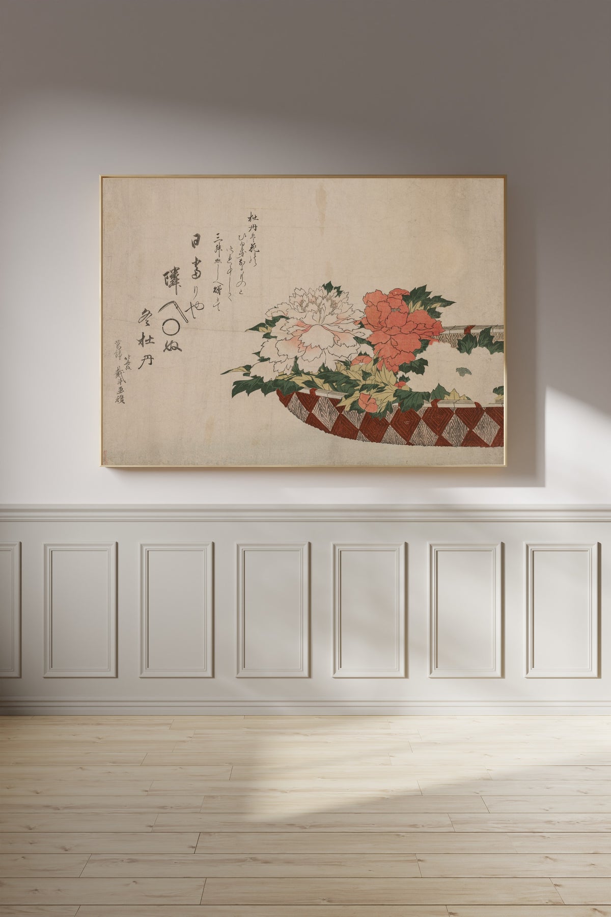 Framed art print of Basket of Peonies by Katsushika Hokusai, on a panelled wall in afternoon light