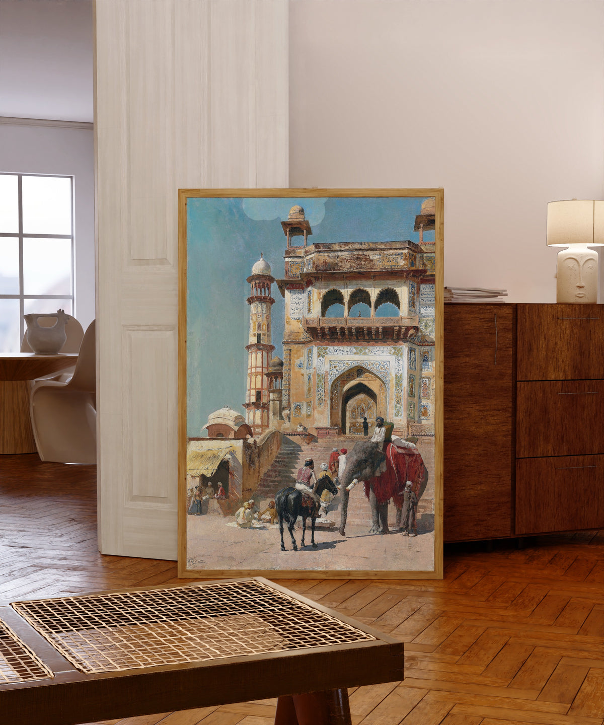 Framed art print of Before the Great Jami Masjid Mosque, Mathura, India by Edwin Lord Weeks, in a light wood frame leaning in a warm room with a parquet floor