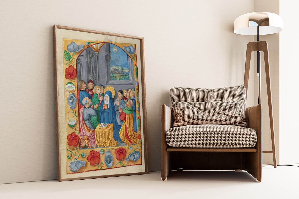 Framed art print of Book of Hours: Pentecost, leaning against a wall beside an armchair and a floor lamp