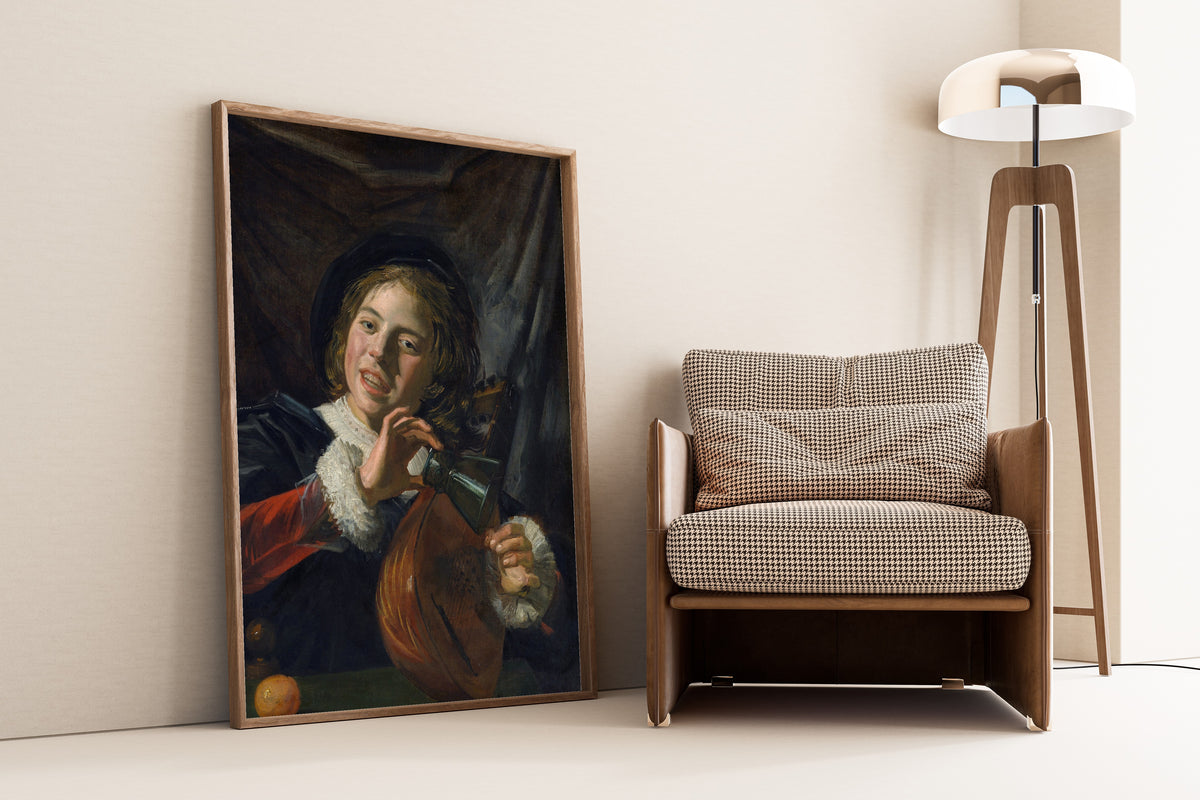 Framed art print of Boy with a Lute by Frans Hals, leaning against a wall beside an armchair and a floor lamp