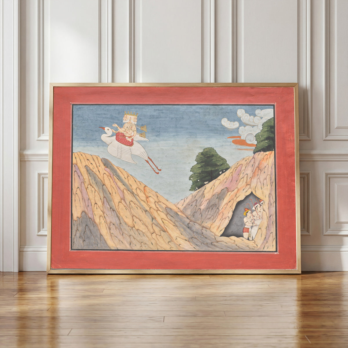 Framed art print of Brahma Hides the Cowherds and the Calves in the Cave by Basohli school, in a light wood frame leaning against a panelled white wall