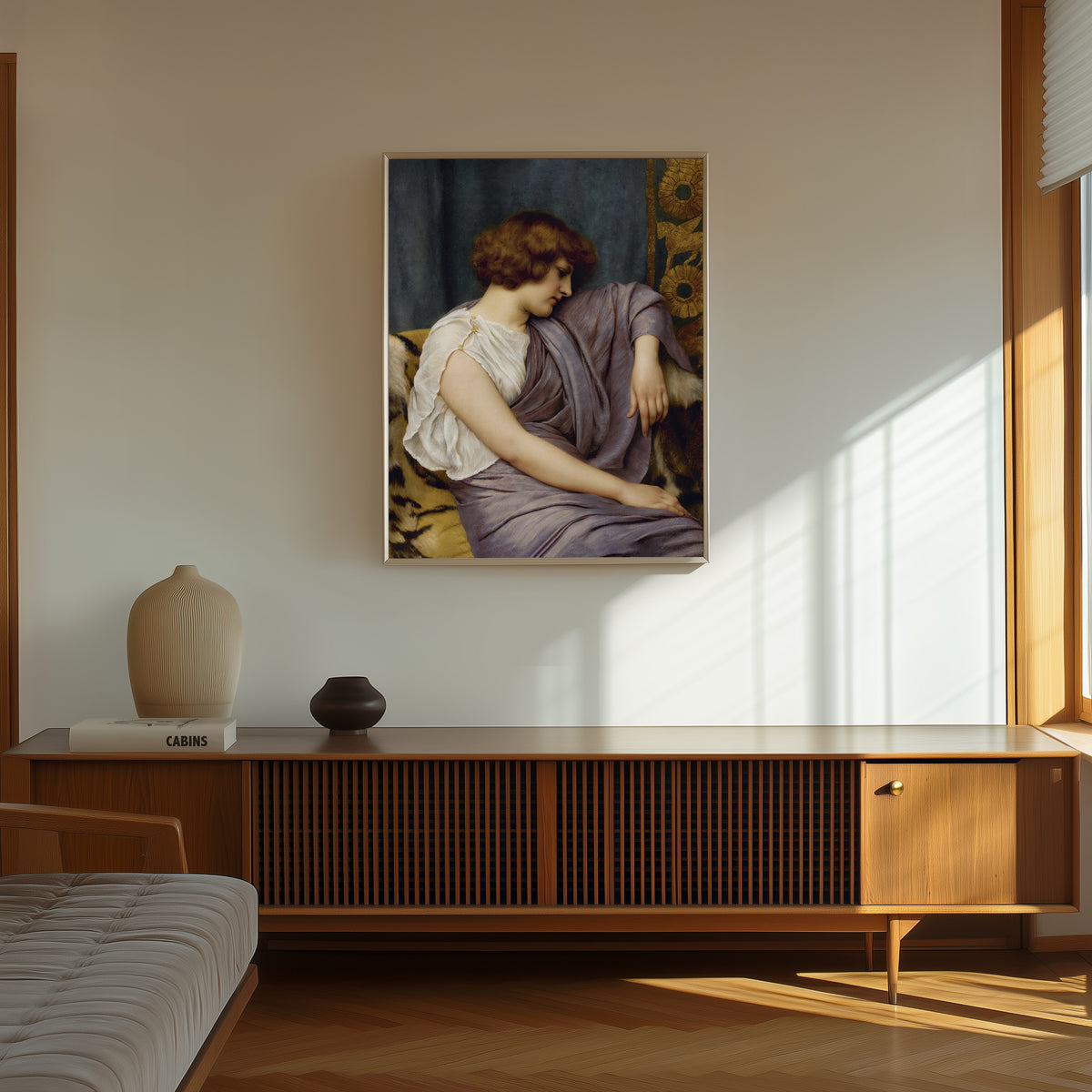 Framed art print of Briseis by John William Godward, in a thin light frame on a sunlit wall above a wooden sideboard