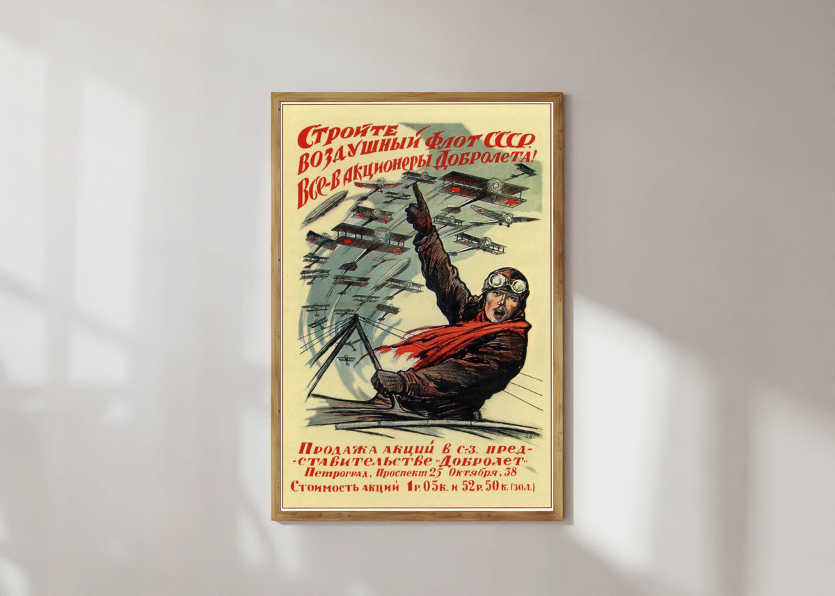 Framed art print of Build the air fleet of the USSR! Everyone, become a shareholder of Dobrolyot! by Ivan Simakov, in a light wood frame on a sunlit white wall