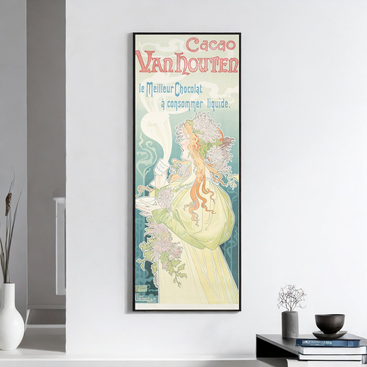 Framed art print of Cacao Van Houten by Henri Privat-Livemont, on a white wall above books and a bowl