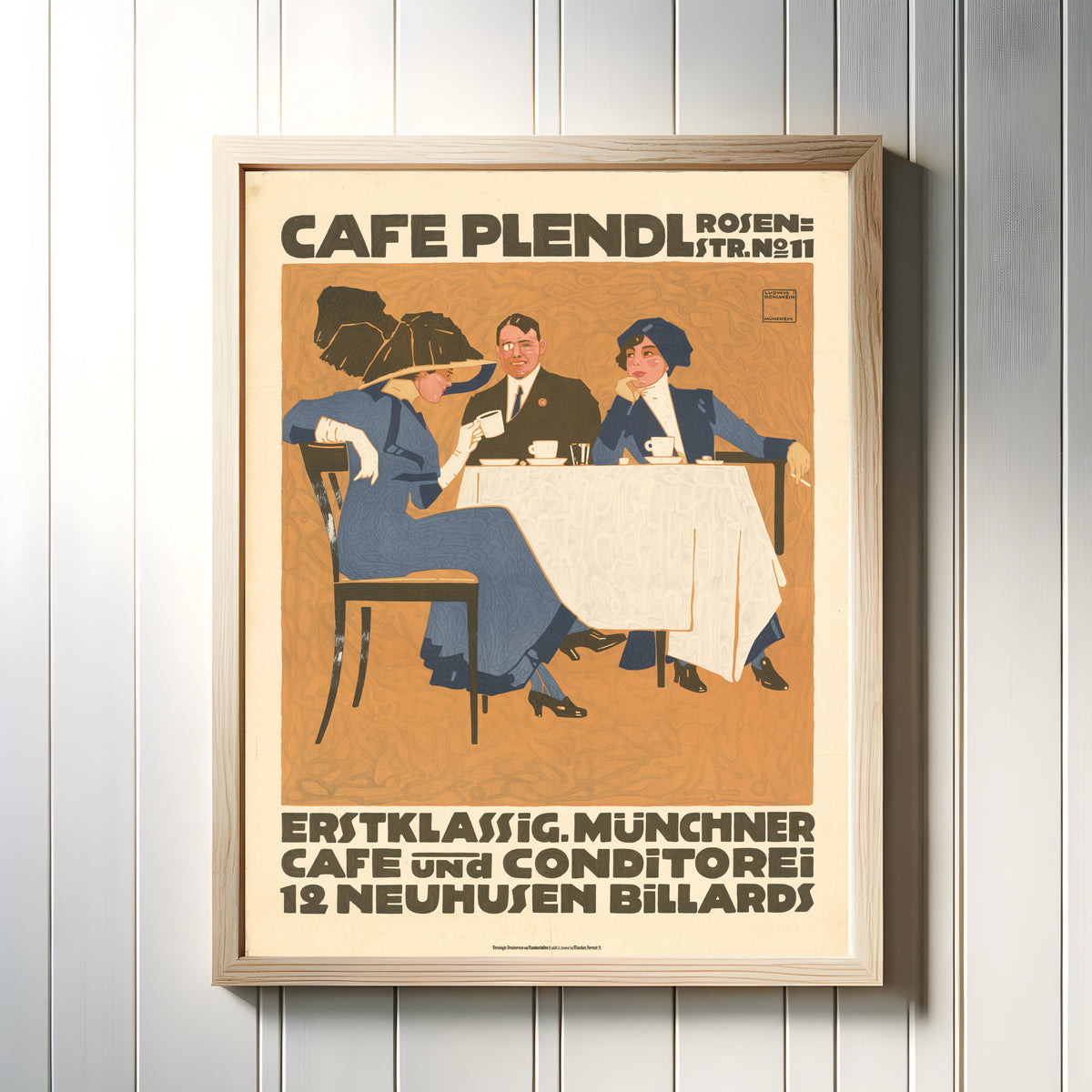 Framed art print of Café Plendl: Münchner Café und Konditorei by Ludwig Hohlwein, in a light wood frame on a white panelled wall