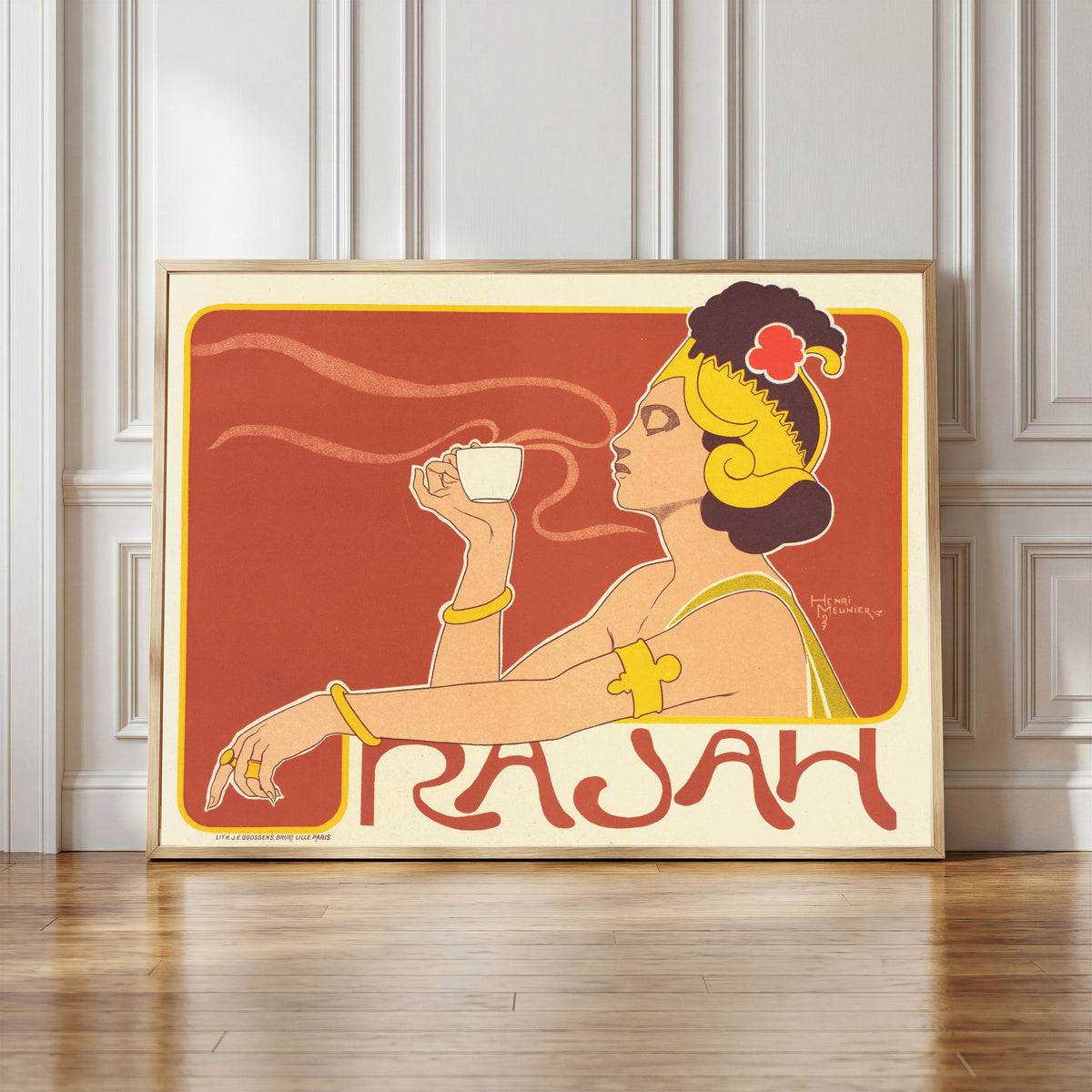 Framed art print of Café Rajah by Henri Meunier, in a light wood frame leaning against a panelled white wall