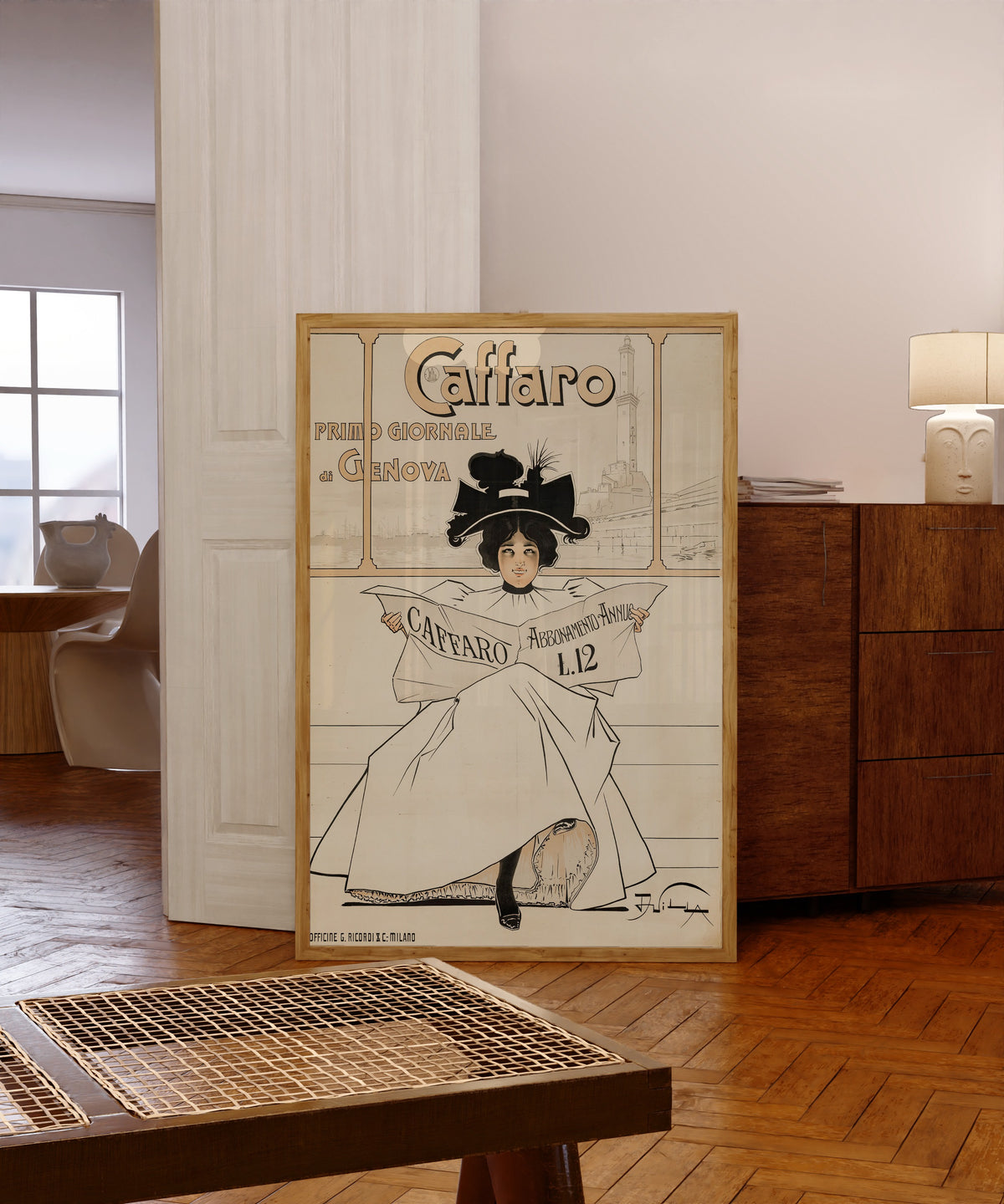 Framed art print of Caffaro: Primo Giornale di Genova by Aleardo Villa, in a light wood frame leaning in a warm room with a parquet floor
