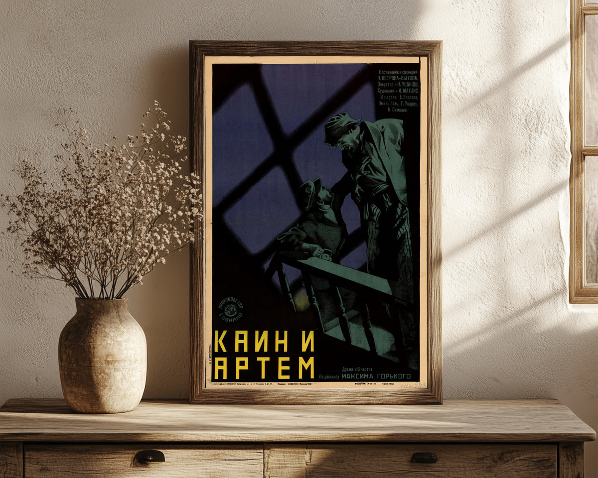 Framed art print of Cain and Artyom by Leonid Voronov, in a dark wood frame leaning on a rustic console beside dried flowers