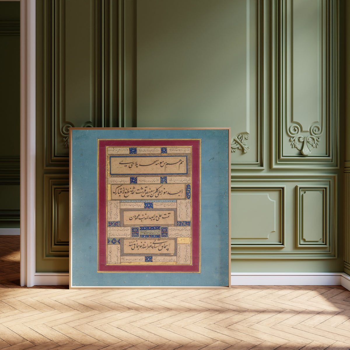 Framed art print of Calligraphic Exercises and Verses of Hafiz by Mahmud ibn Ishaq al-Shahabi, leaning against olive-green panelling on a herringbone floor