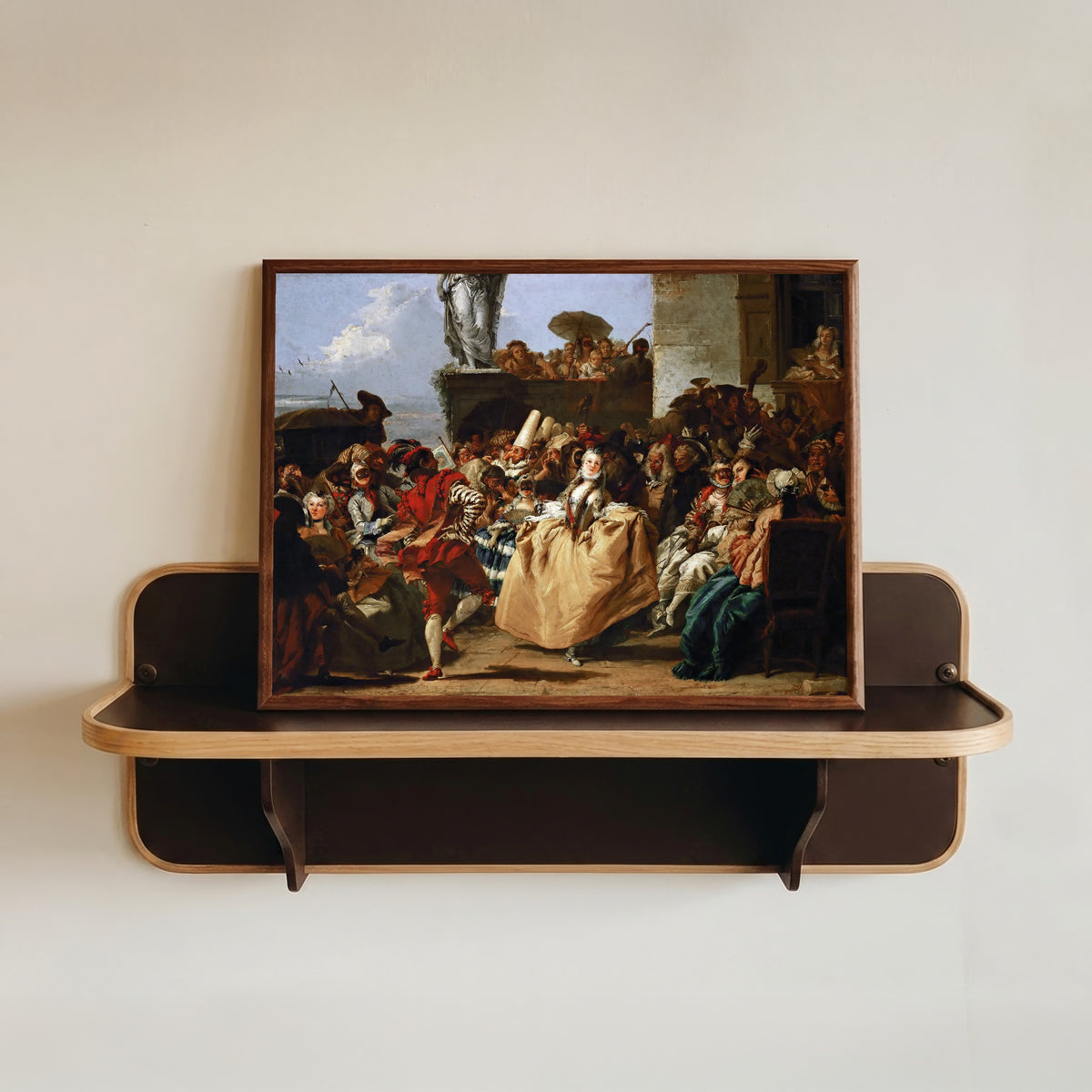 Framed art print of Carnival Scene (The Minuet) by Giovanni Domenico Tiepolo, in a dark wood frame resting on a wall shelf