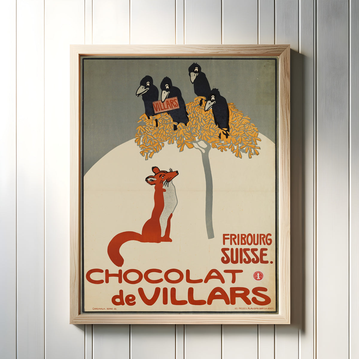 Framed art print of Chocolat de Villars: Fribourg, Suisse by Emil Cardinaux, in a light wood frame on a white panelled wall