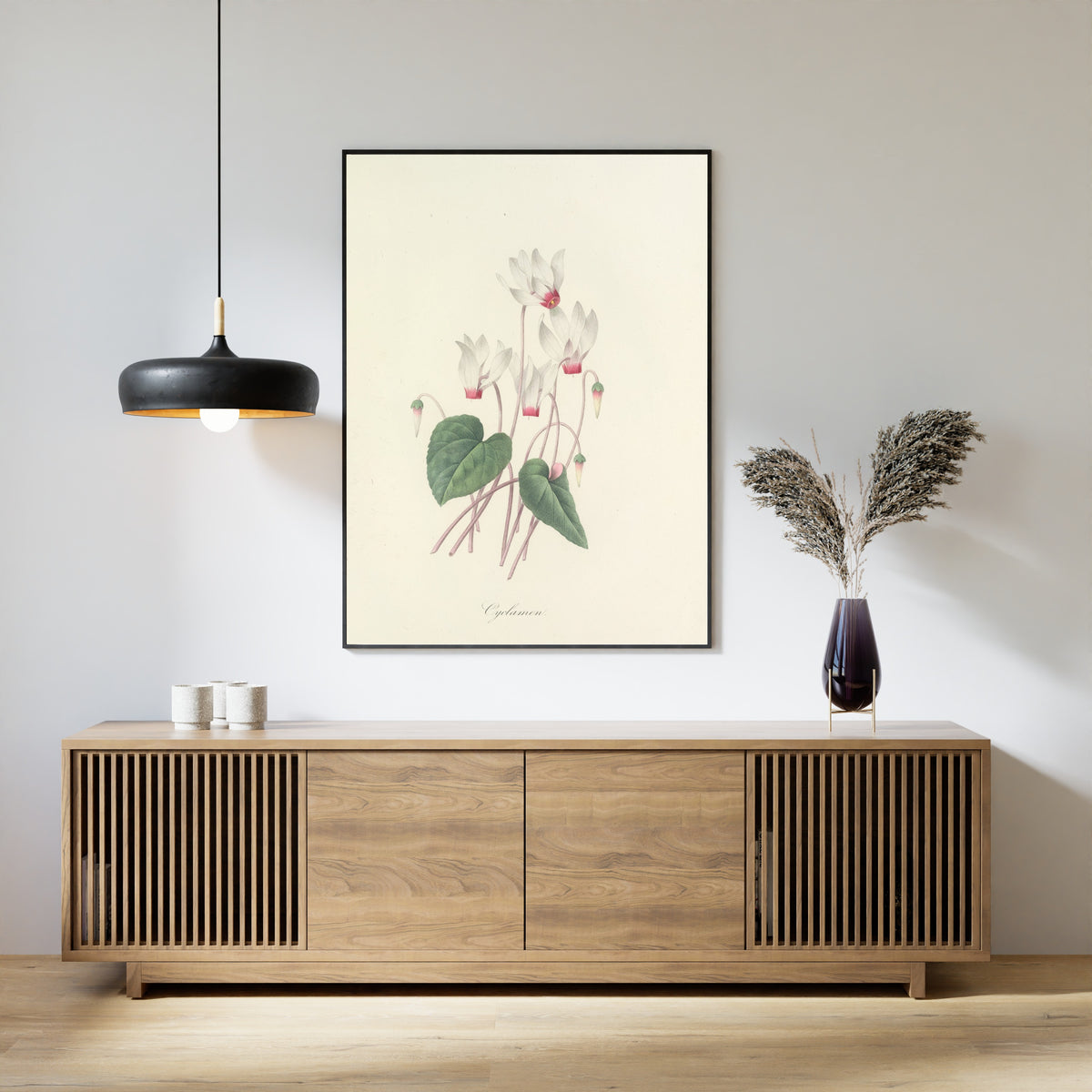Framed art print of Choix des plus belles fleurs, Plate 29: Cyclamen by Pierre-Joseph Redouté, above a slatted wood sideboard