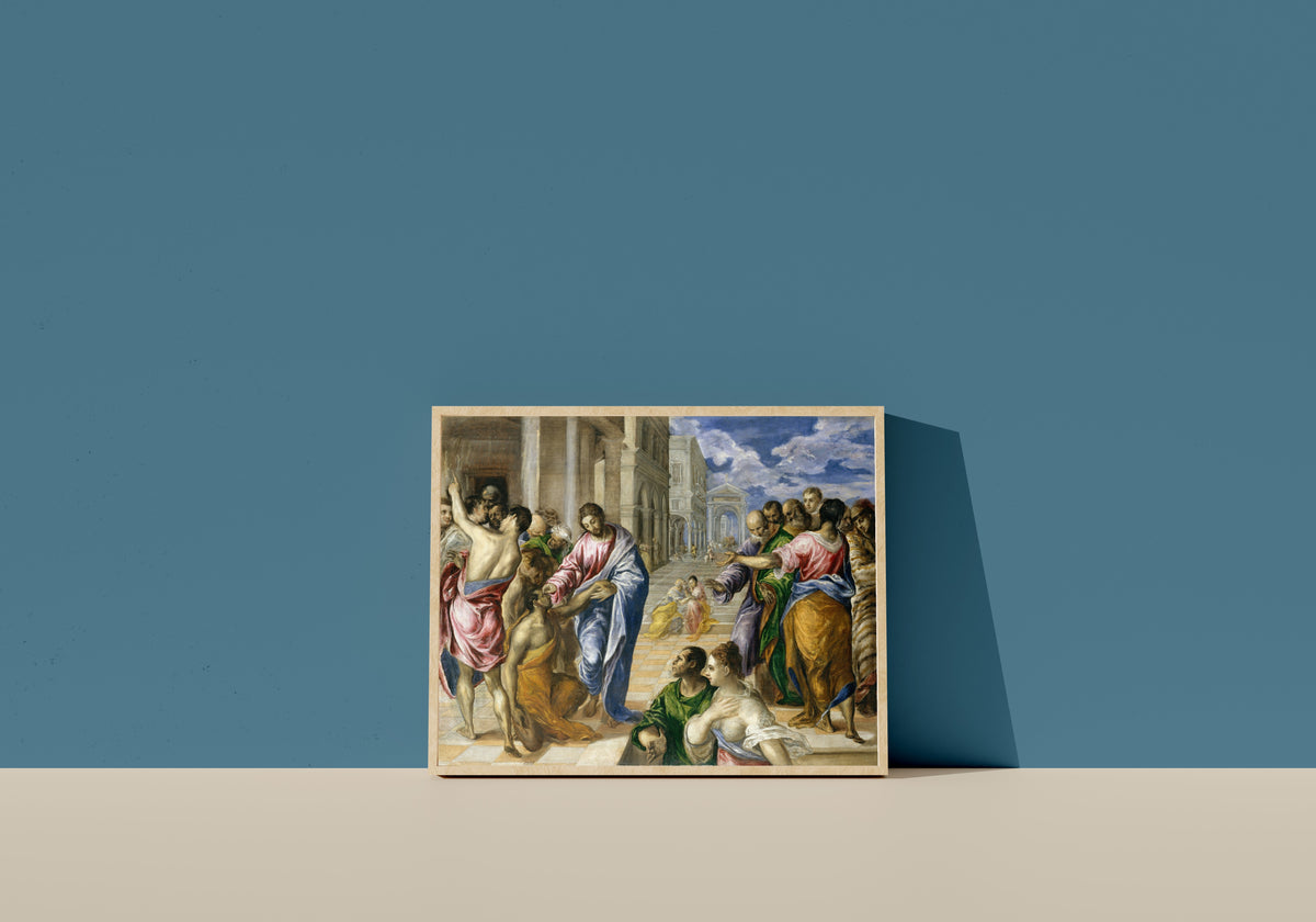 Framed art print of Christ Healing the Blind by El Greco, in a light wood frame leaning on a blue wall